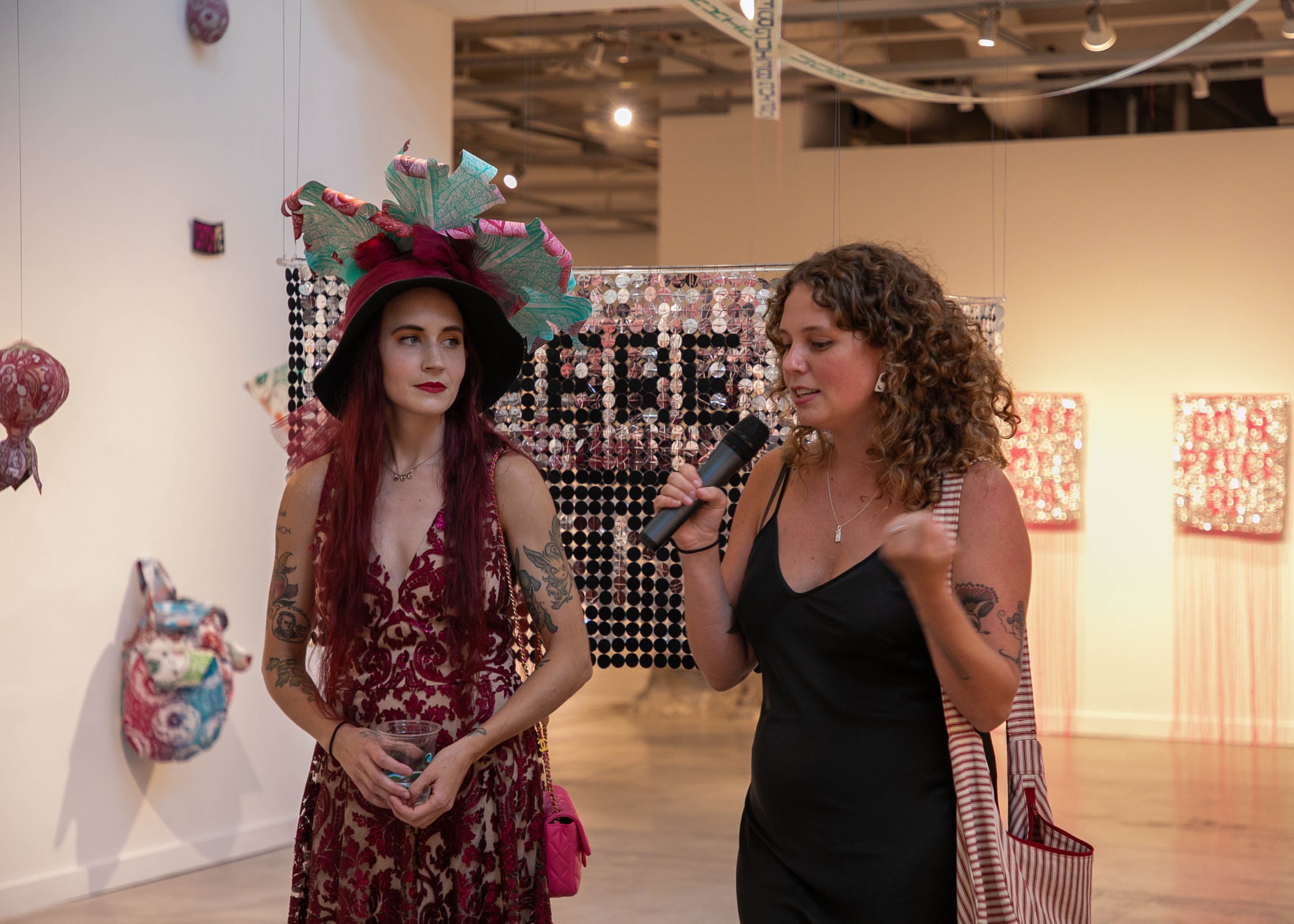 Alex and Stephanie talking into the mic at the gallery opening