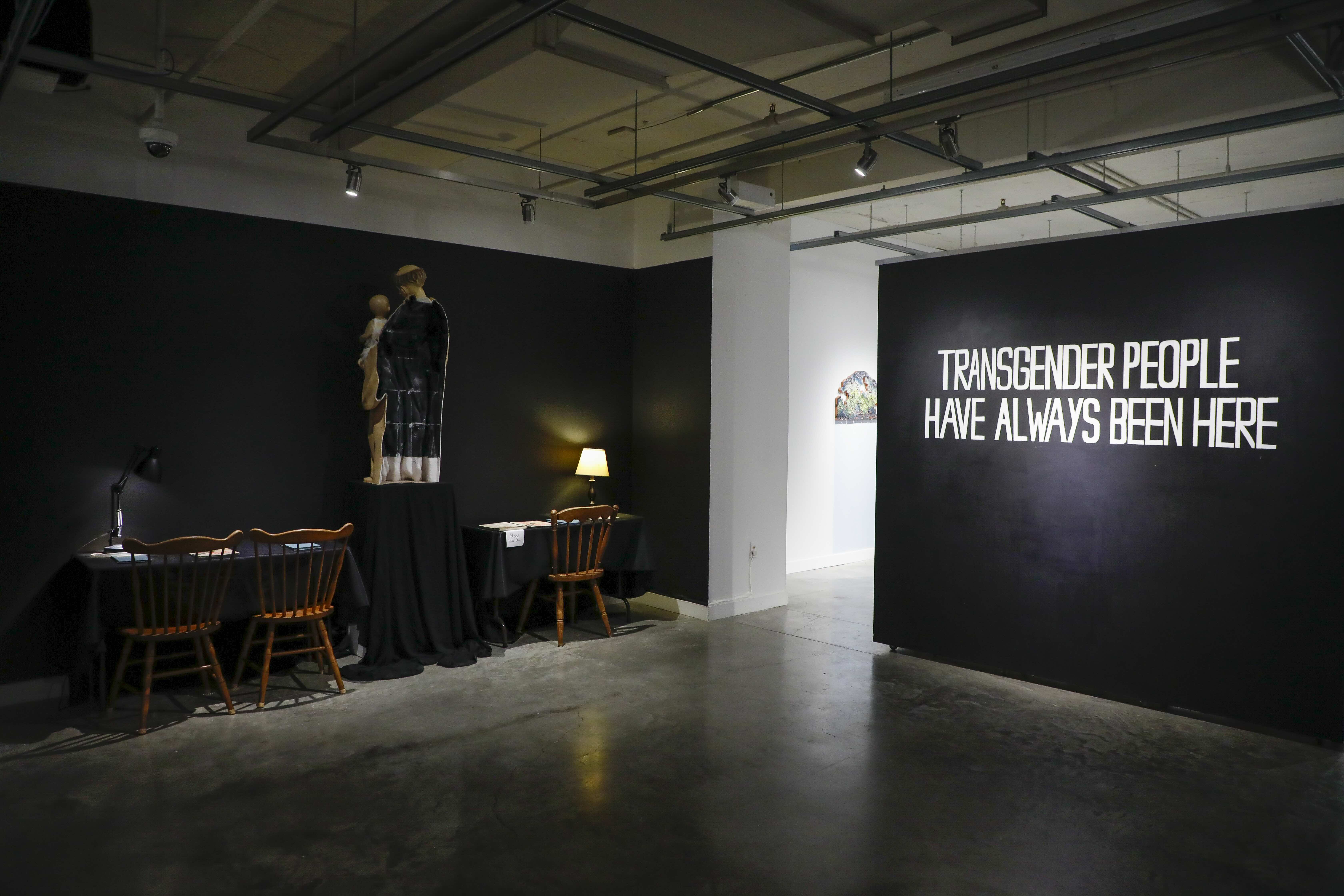 wall painted black with the words transgender people have always been here